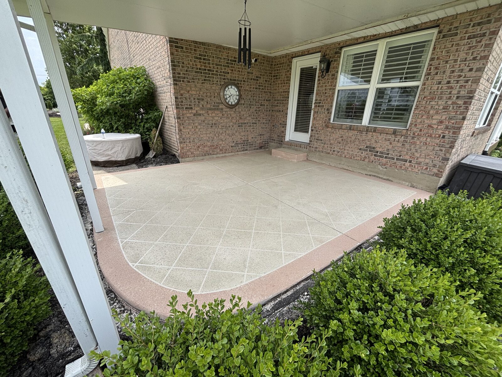 Resurfaced tan patio with decorative border and grid pattern in Hamilton, OH