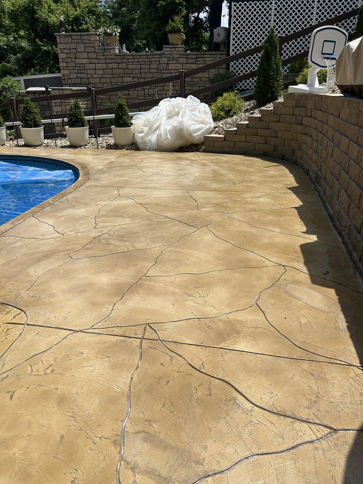 Resurfaced stamped pool deck in warm earth tones at a Hamilton, OH home